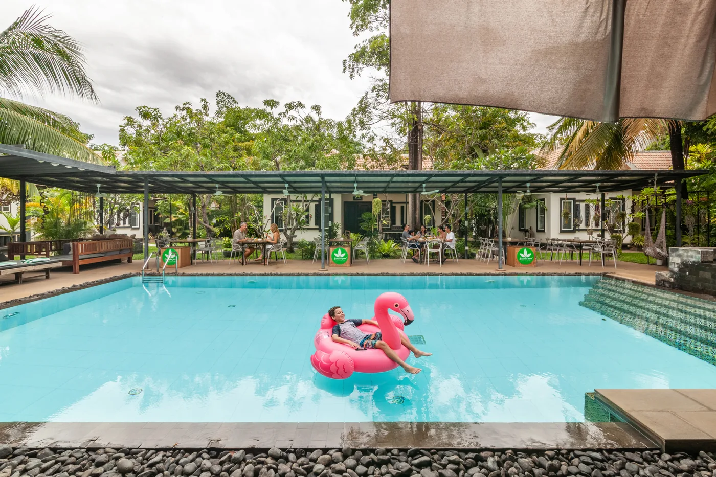 A guest floating on a pink flamingo in the swimming pool