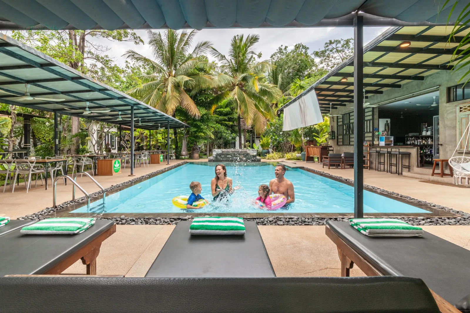 Family enjoying the swimming pool framed by palm trees
